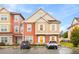 Two-story townhome with orange and beige siding, two-car parking at 2634 Sunrise Shores Dr, Kissimmee, FL 34747