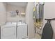 Laundry room with washer, dryer, shelving, and hot water heater at 2634 Sunrise Shores Dr, Kissimmee, FL 34747