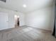 Bedroom with gray carpet and neutral walls, offering a bathroom view at 2649 Howland Blvd, Deltona, FL 32738
