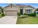 Beige house with two-car garage and landscaped lawn at 2649 Howland Blvd, Deltona, FL 32738