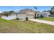 Tan house exterior with solar panels, white vinyl fence, and a two-car garage at 2649 Howland Blvd, Deltona, FL 32738