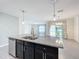 Modern kitchen with island, stainless steel appliances, and granite countertops at 2649 Howland Blvd, Deltona, FL 32738
