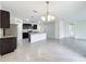 Open concept kitchen with island, dark cabinetry, and view into dining area at 2649 Howland Blvd, Deltona, FL 32738