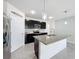 Spacious kitchen featuring dark cabinetry, granite island, and stainless steel refrigerator at 2649 Howland Blvd, Deltona, FL 32738