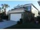 Two-story home with an attached two-car garage, green and white exterior paint, and landscaping at 2803 Lido Key Ct, Kissimmee, FL 34747