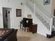 Hallway with a white staircase, a desk area, and neutral tile flooring at 2803 Lido Key Ct, Kissimmee, FL 34747