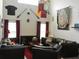 Living room featuring dark leather furniture, themed decor, sconce lighting, and a tall ceiling at 2803 Lido Key Ct, Kissimmee, FL 34747