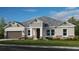 One-story home with gray siding, brown garage door, and stone accents at 2971 Arranmore Dr, Ormond Beach, FL 32174