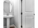 This is a bathroom with a pedestal sink, mirror, and a privacy door at 2975 Arranmore Dr, Ormond Beach, FL 32174