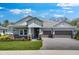 Charming single-story home with a well-manicured lawn, two-car garage, and inviting stone accents at 2975 Arranmore Dr, Ormond Beach, FL 32174