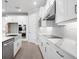 Modern kitchen showcasing white cabinetry, stainless steel appliances, marble countertops, and a stylish range hood at 2975 Arranmore Dr, Ormond Beach, FL 32174