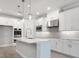 Contemporary kitchen with white cabinets, stainless appliances, marble countertop island, and pendant lighting at 2975 Arranmore Dr, Ormond Beach, FL 32174