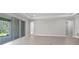 Open living room with sliding glass doors leading to a patio, neutral paint colors, and wood-look tile floors at 2975 Arranmore Dr, Ormond Beach, FL 32174