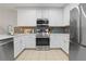 Modern kitchen with white cabinets and stainless steel appliances at 3050 Pirates Retreat Ct # 303, Kissimmee, FL 34747