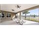 Inviting covered outdoor seating area featuring multiple picnic tables and ceiling fans, with a palm tree view at 3238 Arch Ave, Ormond Beach, FL 32174