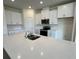Modern kitchen with white cabinets, quartz countertops, and stainless steel appliances at 3238 Arch Ave, Ormond Beach, FL 32174