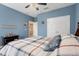Blue bedroom with double closets, ceiling fan, and wood-look floors at 351 Michigan Estates Cir, St Cloud, FL 34769