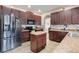 Modern kitchen with dark wood cabinets, stainless steel appliances, and an island at 351 Michigan Estates Cir, St Cloud, FL 34769