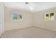 Bright bedroom featuring tile flooring, ceiling fan and natural light from two windows at 4437 Elaine Pl, Orlando, FL 32812