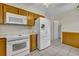 Bright kitchen featuring white appliances and wood cabinets at 4437 Elaine Pl, Orlando, FL 32812