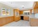 Functional kitchen with wooden cabinetry, white appliances, and tile flooring at 4437 Elaine Pl, Orlando, FL 32812