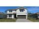Charming two-story home features a gray exterior, well-maintained lawn, and a two-car garage at 5425 Log Grove Ln, Orlando, FL 32829