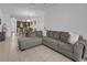 Open living room with L-shaped sofa, kitchen view, and tile floors at 558 S Terrace Spring Dr, Orlando, FL 32828