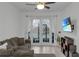 Living room with L-shaped sofa, French doors to patio, and mounted TV at 558 S Terrace Spring Dr, Orlando, FL 32828