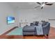 Loft with L-shaped sofa, wood floors, mounted TV, and striped rug at 558 S Terrace Spring Dr, Orlando, FL 32828