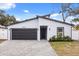 Modern house exterior with gray siding, dark gray garage door, and paved driveway at 722 W Kaley Ave, Orlando, FL 32805