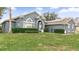 Gray house with a green lawn, walkway, and solar panels at 728 Longford Loop, Apopka, FL 32703