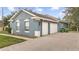 Three-car garage with a gray exterior and brick paver driveway at 728 Longford Loop, Apopka, FL 32703