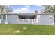 Rear view of a gray house with a covered patio and grassy yard at 728 Longford Loop, Apopka, FL 32703