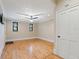 Spacious bedroom with light hardwood floors, neutral walls, ceiling fan, and windows with wooden trim at 832 N Summerlin Ave, Orlando, FL 32803