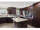 Modern kitchen featuring dark wood cabinets, granite island, and stainless steel appliances at 860 Oak Dr, Groveland, FL 34736