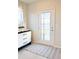 Bright entryway with vintage dresser, rug, and window with roman shade at 10876 Waterwood Aly, Orlando, FL 32829