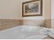 Relaxing bathtub with tile surround and framed art at 1310 Seven Eagles Ct # 301, Reunion, FL 34747