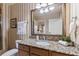 Bathroom with granite vanity, framed mirror, towels, and neutral striped wallpaper at 1310 Seven Eagles Ct # 301, Reunion, FL 34747