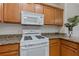 White appliances and wood cabinets in kitchen at 1310 Seven Eagles Ct # 301, Reunion, FL 34747