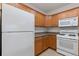 White appliances and wood cabinets in kitchen at 1310 Seven Eagles Ct # 301, Reunion, FL 34747