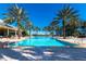 Resort-style pool with palm trees and comfortable lounge area at 1310 Seven Eagles Ct # 301, Reunion, FL 34747