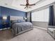 Main bedroom with gray upholstered bed and blue accent wall at 1402 Lisbon Ct, Davenport, FL 33896