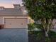 Two-car garage with brick driveway and lush landscaping at 1402 Lisbon Ct, Davenport, FL 33896
