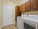 Bright laundry room with washer, dryer and cabinets at 1402 Lisbon Ct, Davenport, FL 33896