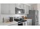 Modern kitchen island with white quartz countertop and stainless steel appliances at 1672 Hummingbird Rd, Winter Haven, FL 33884