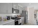 Modern kitchen with gray cabinets, white quartz countertops, and stainless steel appliances at 1680 Hummingbird Rd, Winter Haven, FL 33884