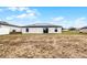 Rear view of the home with solar panels and a spacious backyard at 1952 Piedmont Ct, Mascotte, FL 34753