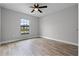 Bright bedroom features a ceiling fan, wood-look floors, and a window at 1952 Piedmont Ct, Mascotte, FL 34753