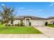 Inviting single-story home featuring a well-maintained lawn, enhanced curb appeal and attached garage at 1952 Piedmont Ct, Mascotte, FL 34753
