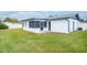 Spacious backyard with grassy lawn and screened patio at 2932 Carriage Dr, Daytona Beach, FL 32119